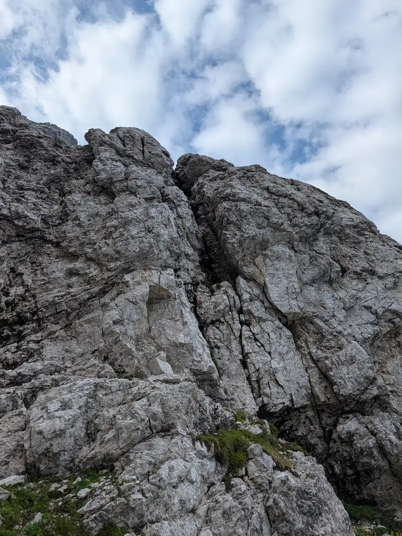 Crux of the route marked with a cairn. The chimney is not that pleasant and exposed a little but not overly difficult (around III). There is an easier dihedral ascent to its right however the rock is more brittle in there. Other ways might be even more difficult.