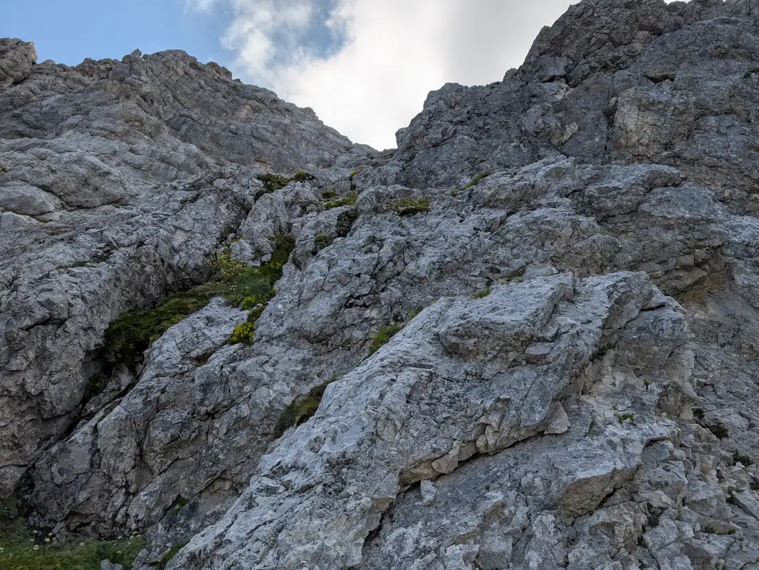 Last climbing section - passage below overhanging rocks and slab scramble (II+)