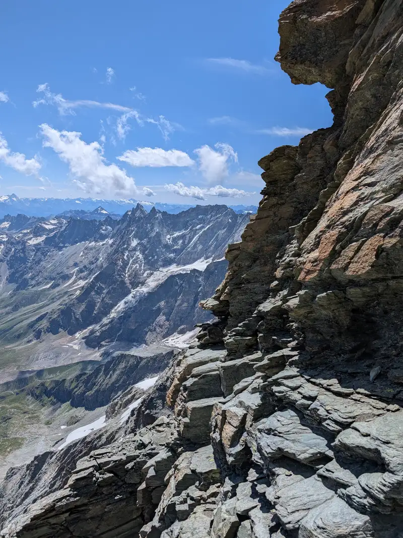 Exposed traverse and chimney from previous photos can be seen in the background, were climbing up again in the direction of ridge just after crossing that snowfield below. It is protected with via-ferrata like cable.