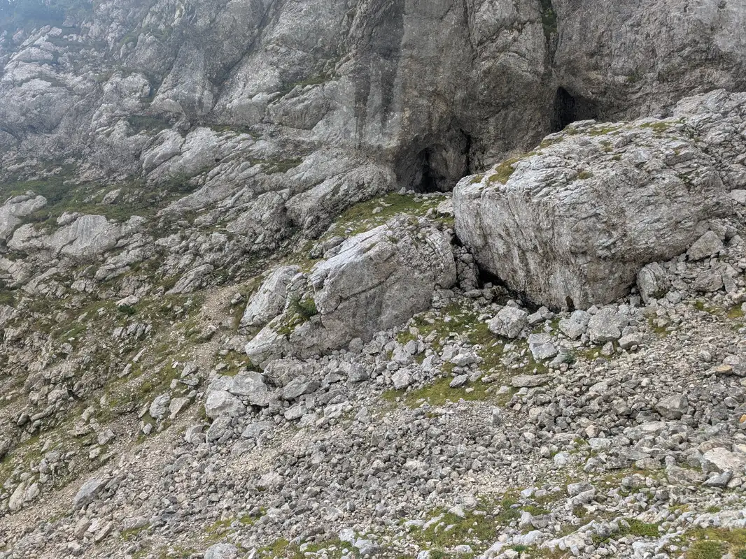 Below this rocks we should turn left sligthly and head up, leaving these cave-like holes on the left.
