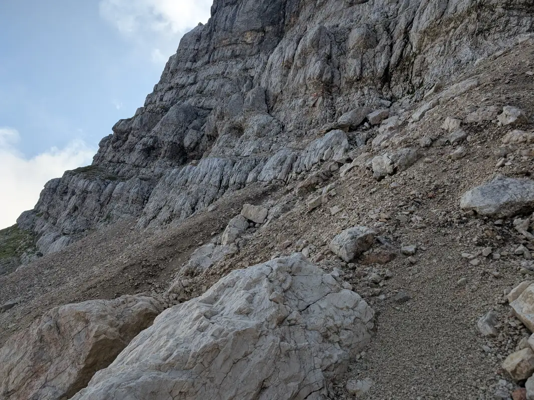 Terrain in the platform. We can either cross it below this rocky ledges or ascend and enter the first distinct ledge that will take us to the start of the climb (grassy ledge visible at the end)
